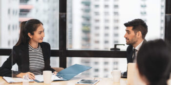A lawyer and general counsel discussing legal matters around a table.